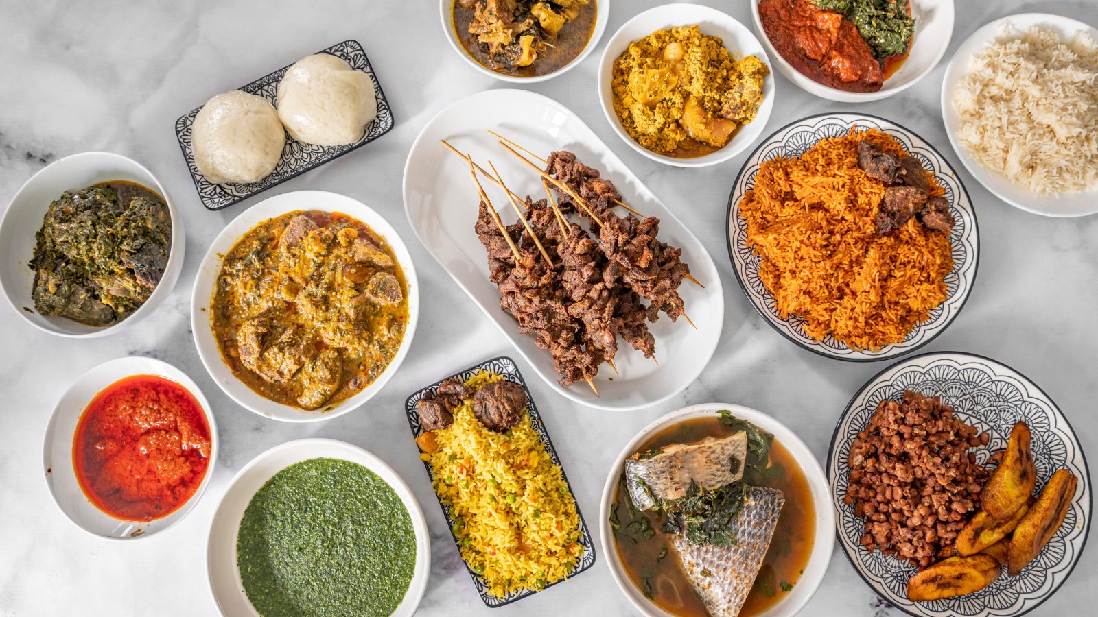Traditional Nigerian culinary spread featuring jollof rice, soups, fufu and grilled meat