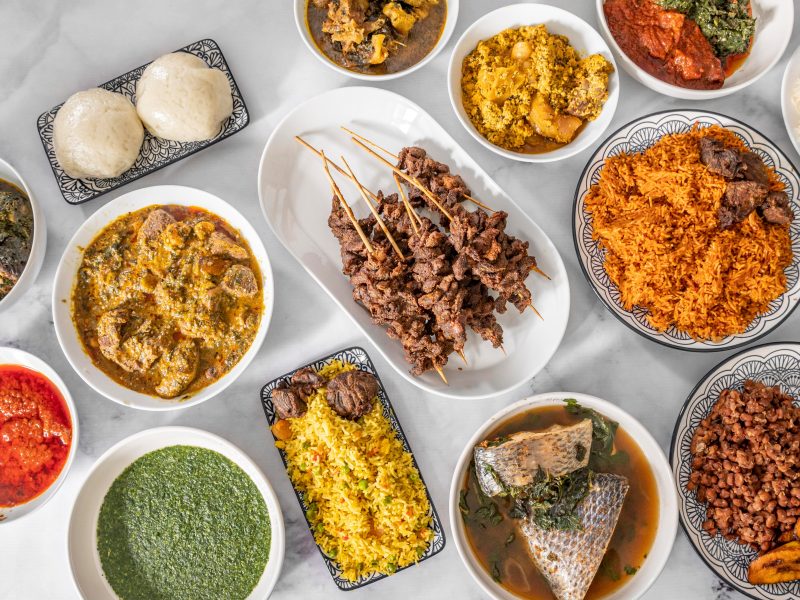 Traditional Nigerian culinary spread featuring jollof rice, soups, fufu and grilled meat